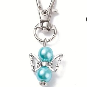 Pearlized angel bag charm NWOT includes box